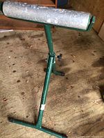 Full view of green steel roller stand showing roller, frame and feet