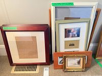 Group of assorted frames leaning against wall