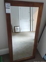 Full view of rectangular floor mirror leaning on wall