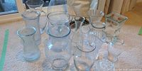 Group shot of all ten clear glass vases on carpeted floor