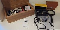 Overview showing camera, box, leather case, magnifying glass, wooden box with playing cards
