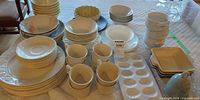 Overview of stacked plates, bowls, mugs, egg tray and serving pieces