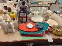 Countertop view of toiletries, ceramic holders, trays, jewelry box and heat pad