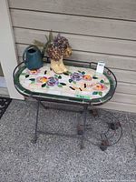 Full view of patio table with mosaic top and metal frame