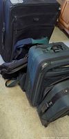 Group of four rolling suitcases and bags
