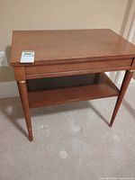 Full view of brown veneer side table front and top