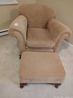 Front view of armchair and ottoman showing upholstery and overall condition