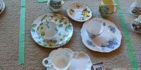 Several tea sets; center right shows white bone china saucer with blue flowers and matching teacup (lot contents)
