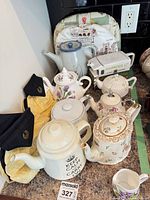 Group shot of all teapots and creamer on countertop