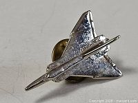 Front view of silver-tone Avro Arrow pin with butterfly clasp