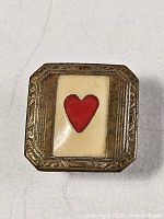 Front view showing brass frame, cream enamel and red heart