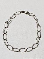 Full view of sterling silver oval link bracelet with clasp