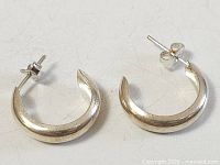 Front view of both sterling silver hoop earrings showing overall shape and finish