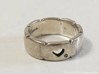 Full view of ring exterior showing heart cutout, diamond inset, and scalloped edge