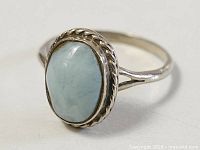 Top view showing oval blue cabochon stone and rope border