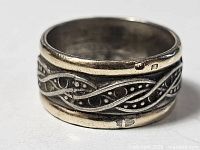 Ring showing 14K gold rims and sterling silver patterned band