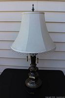 Full view of brass table lamp with shade