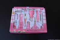 Front of unopened Baby Care Kit box showing ten pink grooming tools