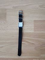 Full view of Guess wristwatch laid flat showing strap length and square case