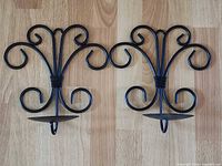 Front view of both matching wrought iron scroll wall sconces