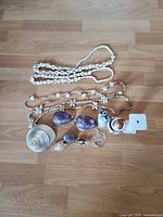 All items laid out showing necklaces, shells, figurines, keychain, decorative column