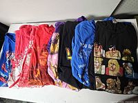 All eight folded t-shirts laid out side by side