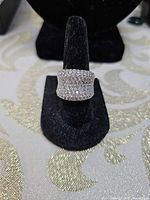 Front view of cubic zirconia pavé ring on display stand