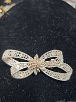 Front view of silver filigree bow brooch