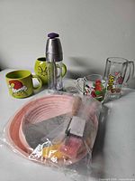 All items overview – two Grinch mugs, clear cylinder cookie press, Garfield mug, Daisy Duck stein, sealed sourdough kit