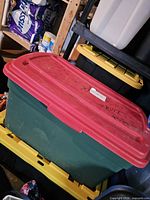 Green tote with red lid containing electronics lot