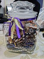 Front view of glass jar packed with assorted jewelry pieces
