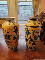 Two matching yellow-ground blue-decorated porcelain vases standing side by side