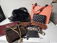 Group shot of all purses, wallets, belt on tabletop