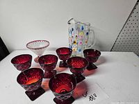 Group view of ruby cups, clear dessert dish, and crystal pitcher