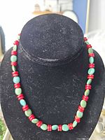 Full view of turquoise and coral beaded necklace displayed on bust
