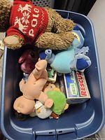 Top view of tote showing plush dog, Stitch plush, pig plush, vinyl baby doll, Hess Rescue truck box and other small plush