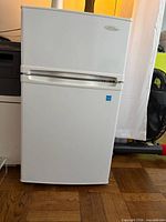 Front view of white Danby two-door mini fridge