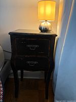 Front view of black two-drawer side table with distressed finish