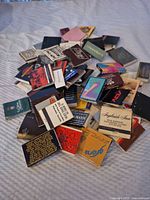 Pile of assorted vintage matchbooks on fabric surface