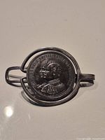 Front view of money clip showing mounted Portuguese coin and overall structure