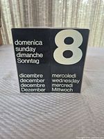 Front view showing cubes displaying day, date, month in multiple languages