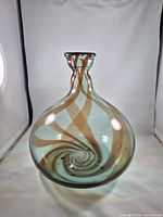 Front view of bulbous aqua/teal glass vase showing amber swirl and bubble inclusions
