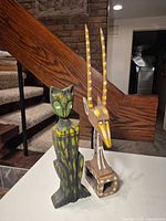 Front view of both wood figurines showing overall forms and paint details