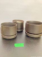 Three matte black Arabia ceramic planters on tabletop