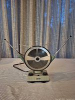 Front view of circular amplified antenna with extended rabbit-ear rods on ribbed base