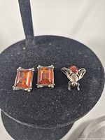 Overall view of brooch and both earrings on display stand