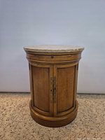 Front view showing overall cylindrical wooden body and marble top