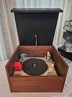 Turntable open showing platter, tonearm, AKG box