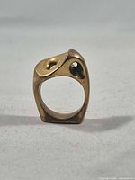 front view of sculptural brass ring showing abstract openwork design