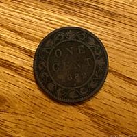 Reverse side showing ONE CENT 1882 within vine design